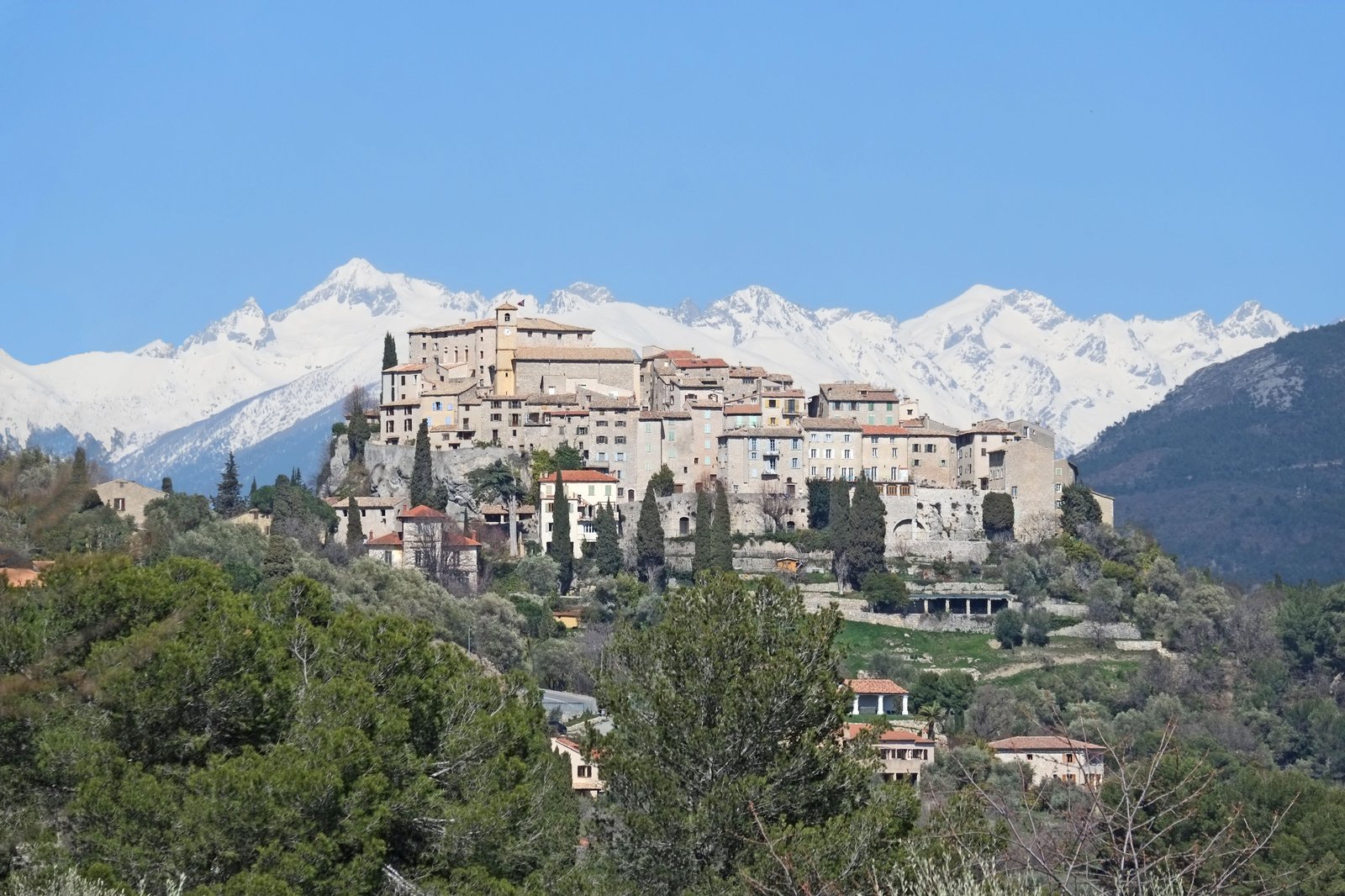 Vue du village de Carros avec le Mercantour enneigé