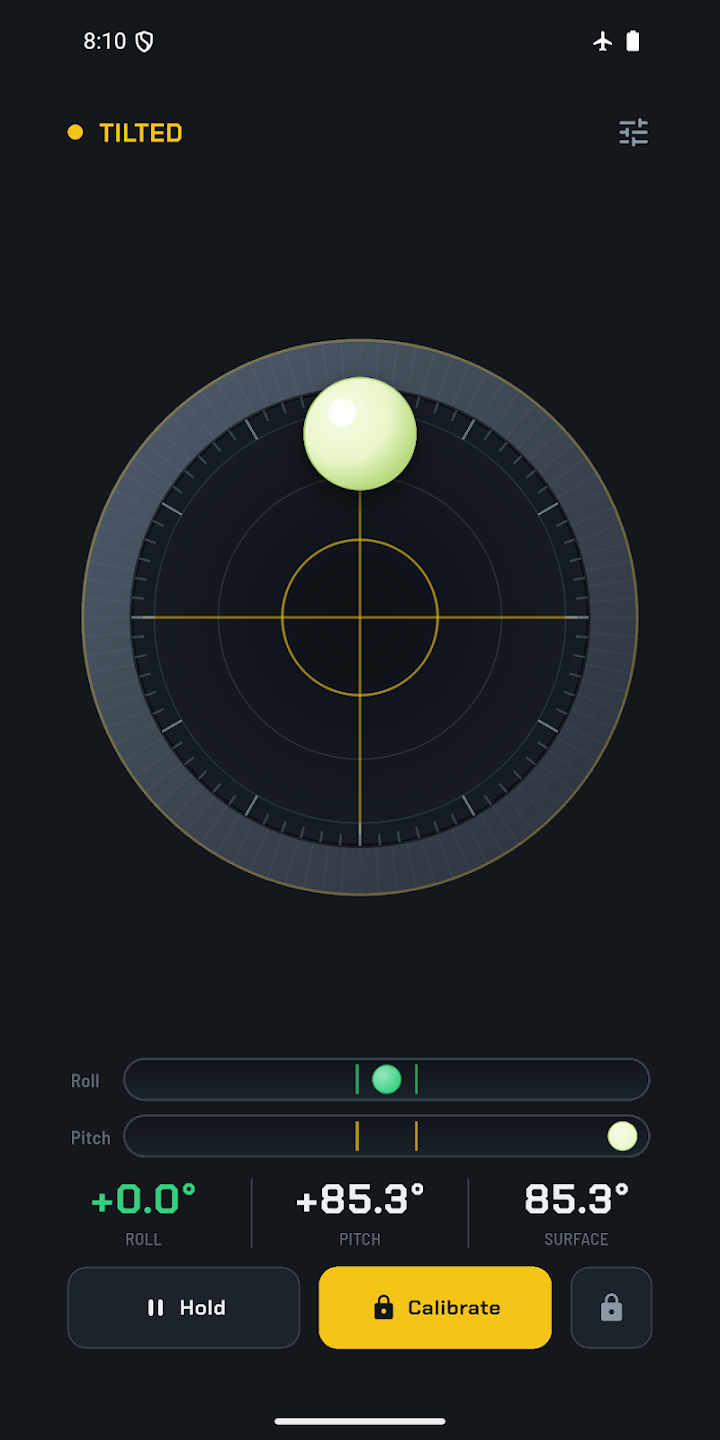Ecran de niveau a bulle sur fond noir, avec un cadran circulaire gradue au centre duquel une bulle jaune est decentree vers le haut, la mention Tilted en orange, et les valeurs +0,0 et +85,3 degres en dessous